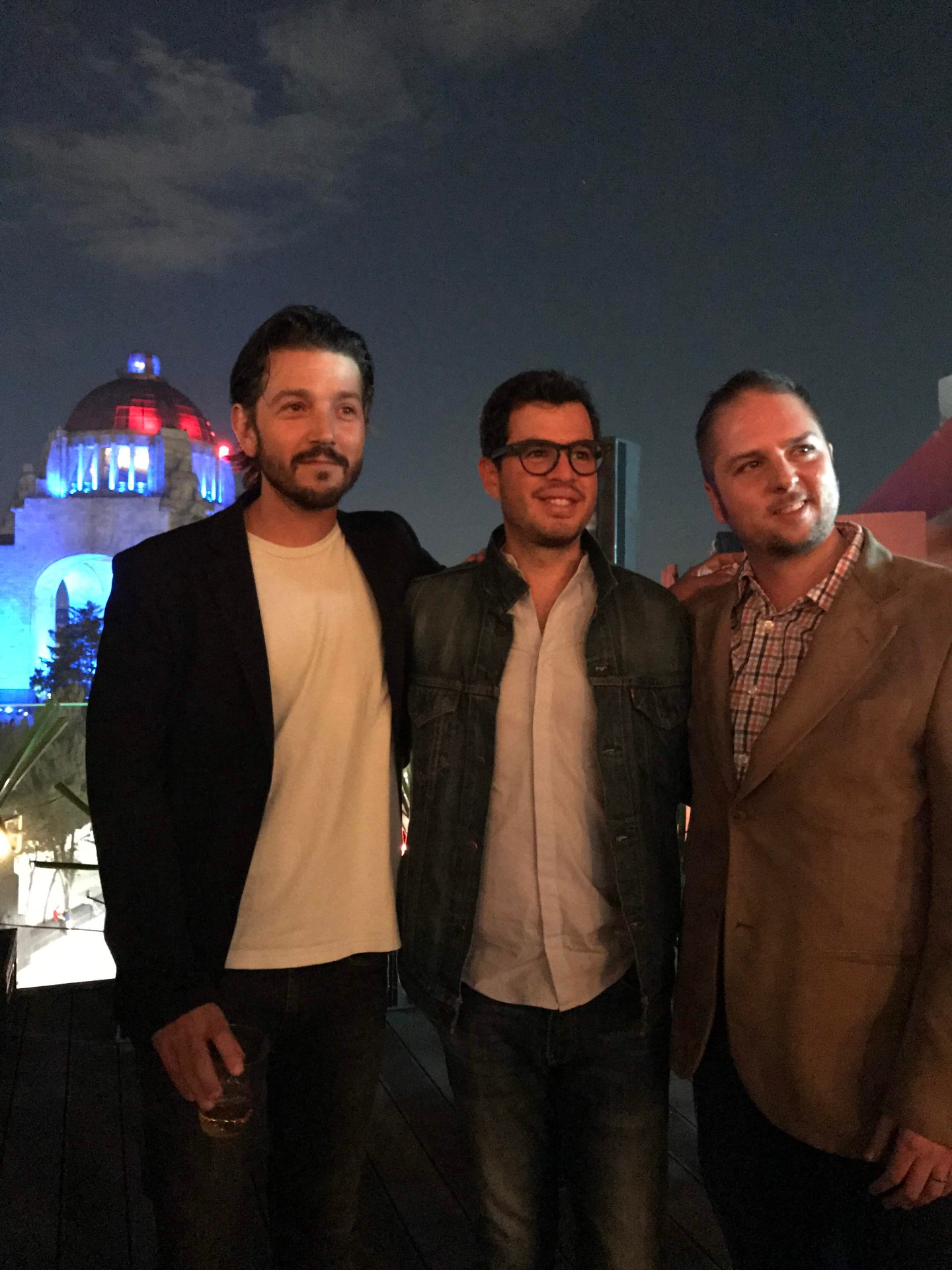 Invitados en la terraza de noche con el Monumento iluminado